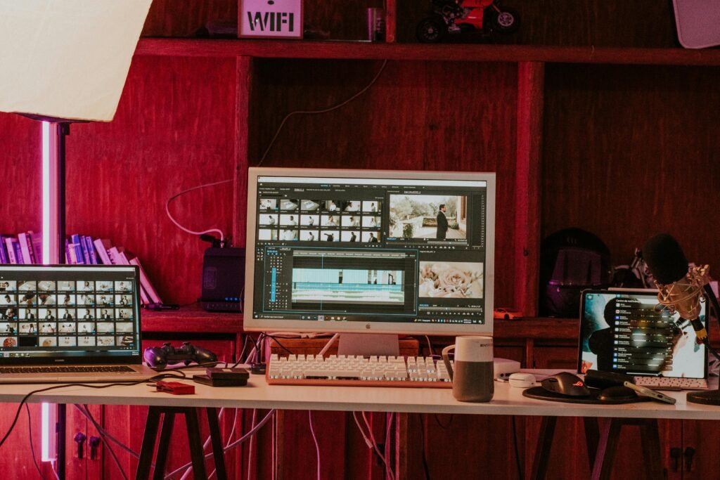 A professional video editing workspace featuring monitors, keyboard, and microphones in a studio setting.